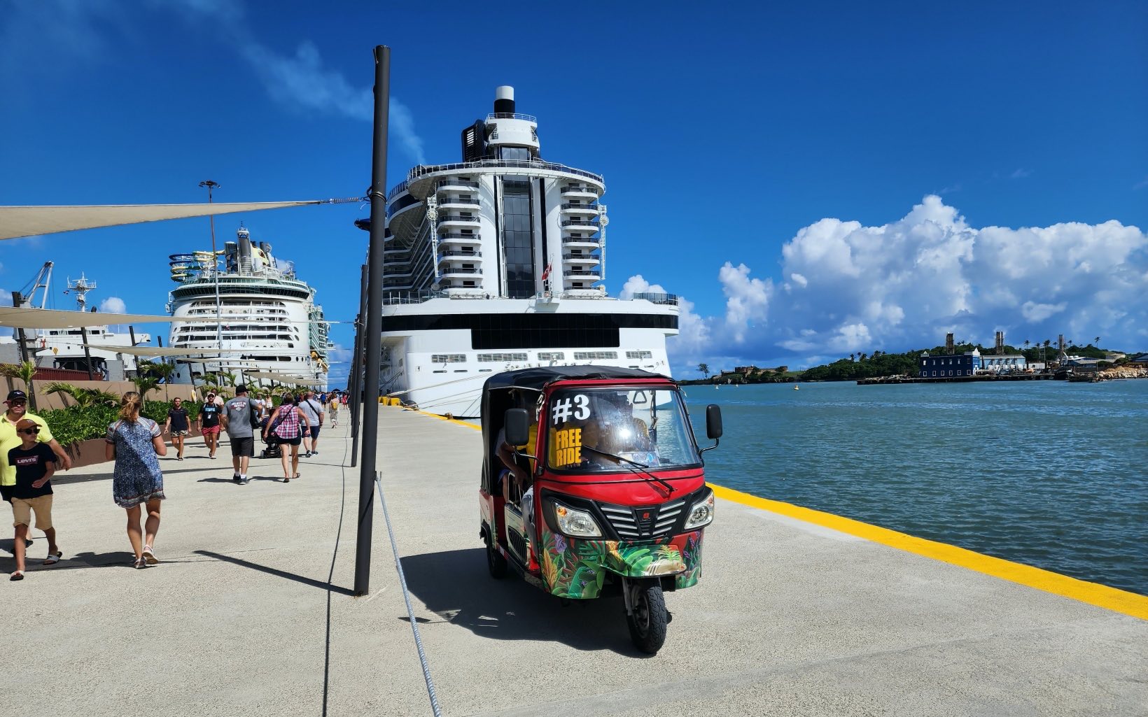 Cruise passengers walk in the pier at Taino Bay